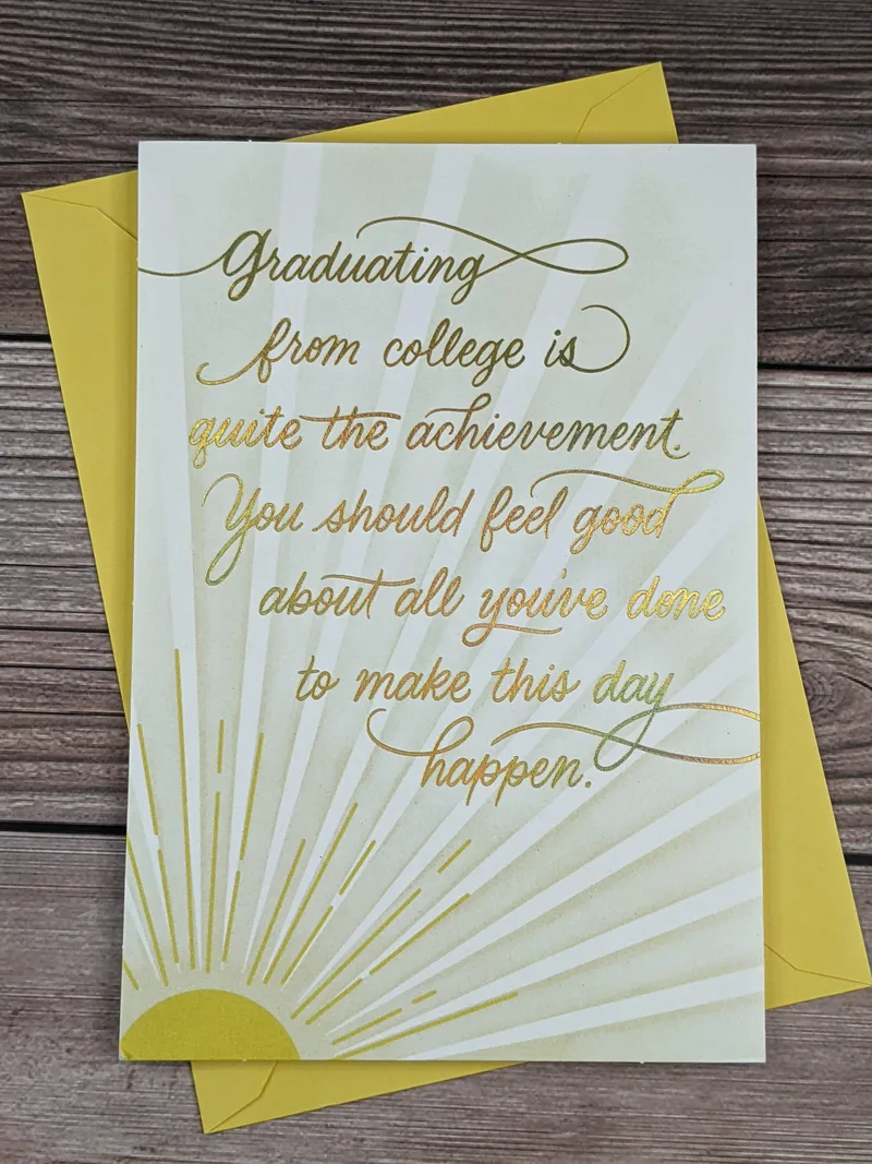 A Hallmark graduation greeting card for a college grad, with an image of a yellow sunshine on the front cover.