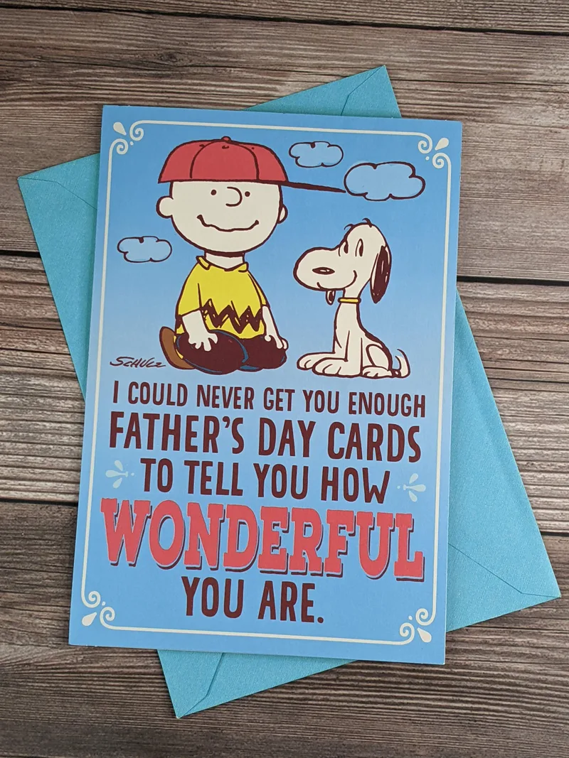 A Peanuts-characters themed blue Father's Day greeting card with Charlie Brown and Snoopy on the cover.