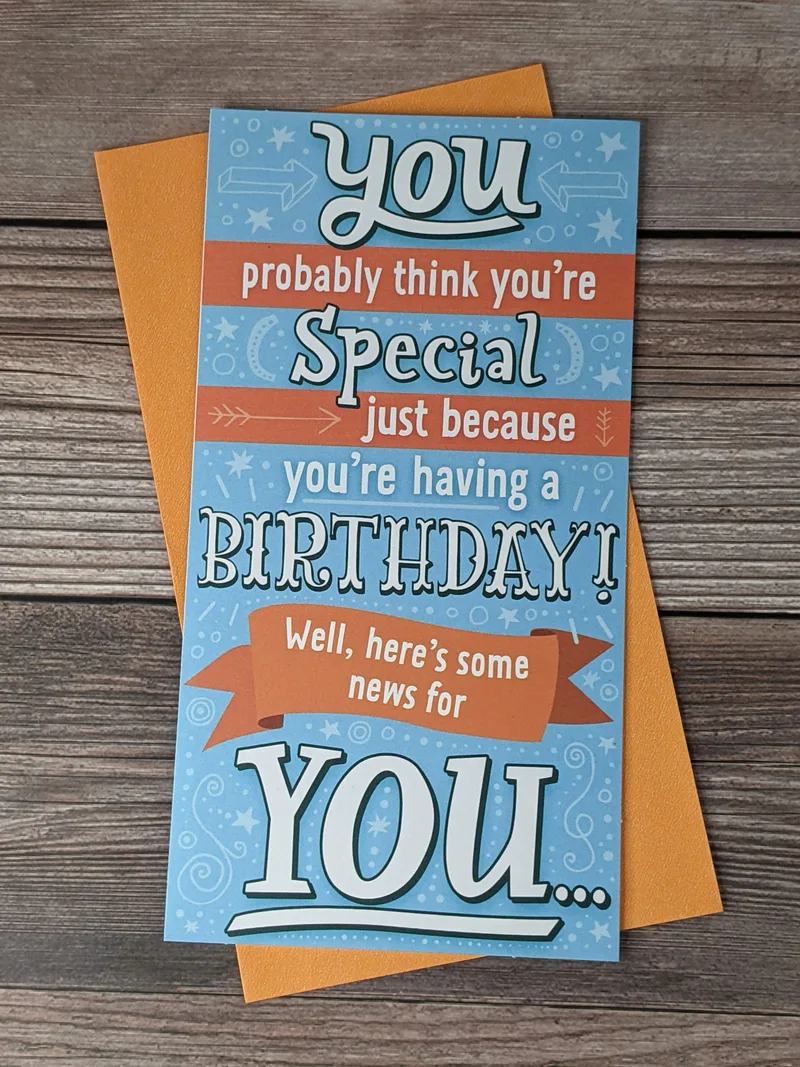 A birthday greeting card with a blue and orange cover that has a funny message.